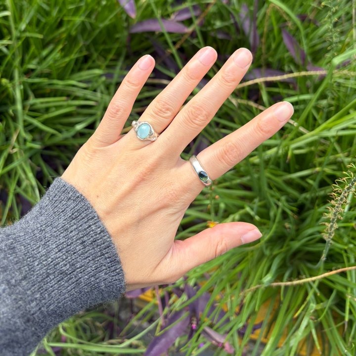 Dos anillos de plata puestos, uno con larimar